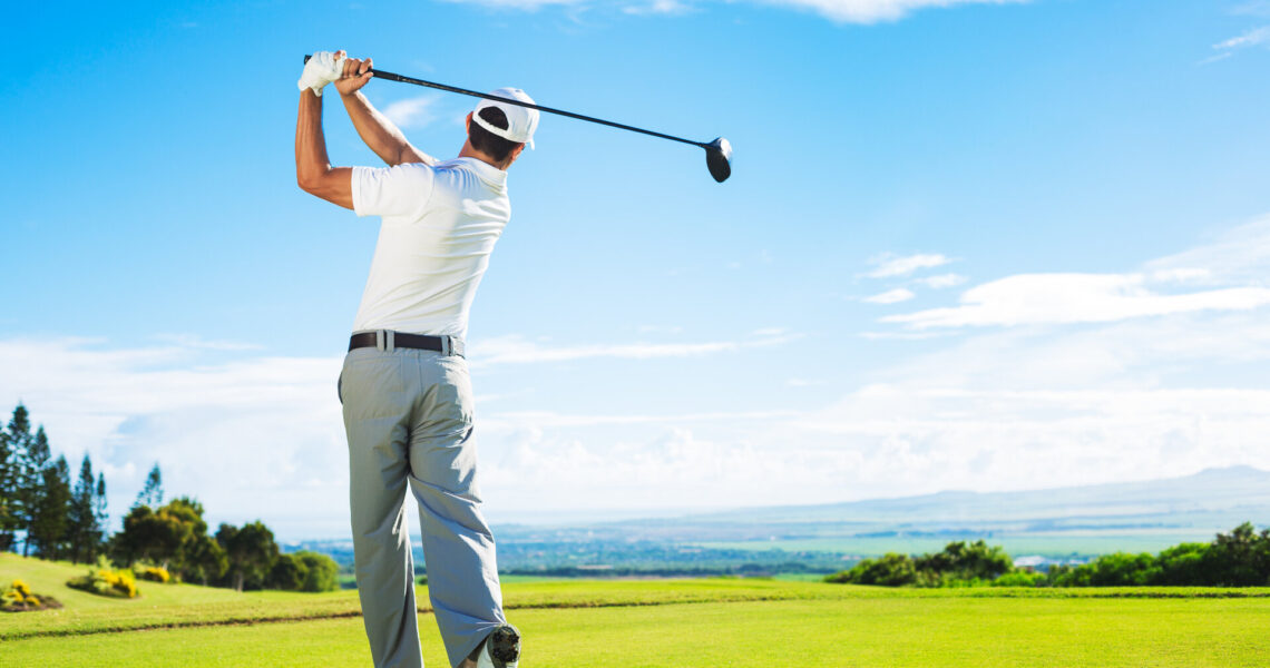 Mann spielt Golf auf einem schönen, sonnigen, grünen Golfplatz. Hitting Golf Ball nach unten das Fairway vom Tee mit Fahrer.
